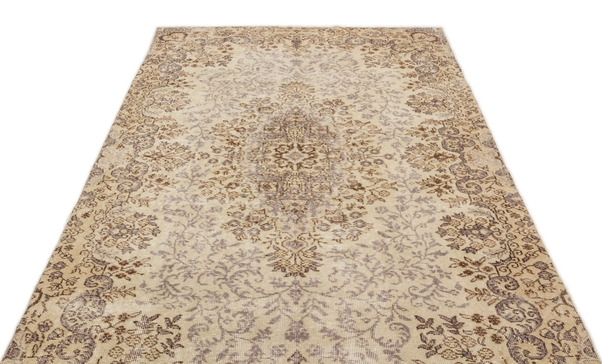 Beige and brown vintage-style rug with a distressed floral medallion pattern on a white background.