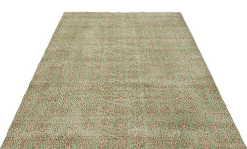 Load image 1 in gallery view. Sage green and beige rug with a distressed, repeating floral medallion pattern on a white background.