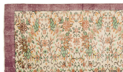 Load image 1 in gallery view. Cream rug with a distressed floral pattern in orange and green, featuring a wide plum-colored border.