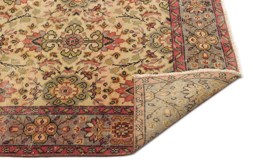 Load image 1 in gallery view. Beige, red, and olive green traditional rug with a floral medallion pattern and a folded corner on a white background.