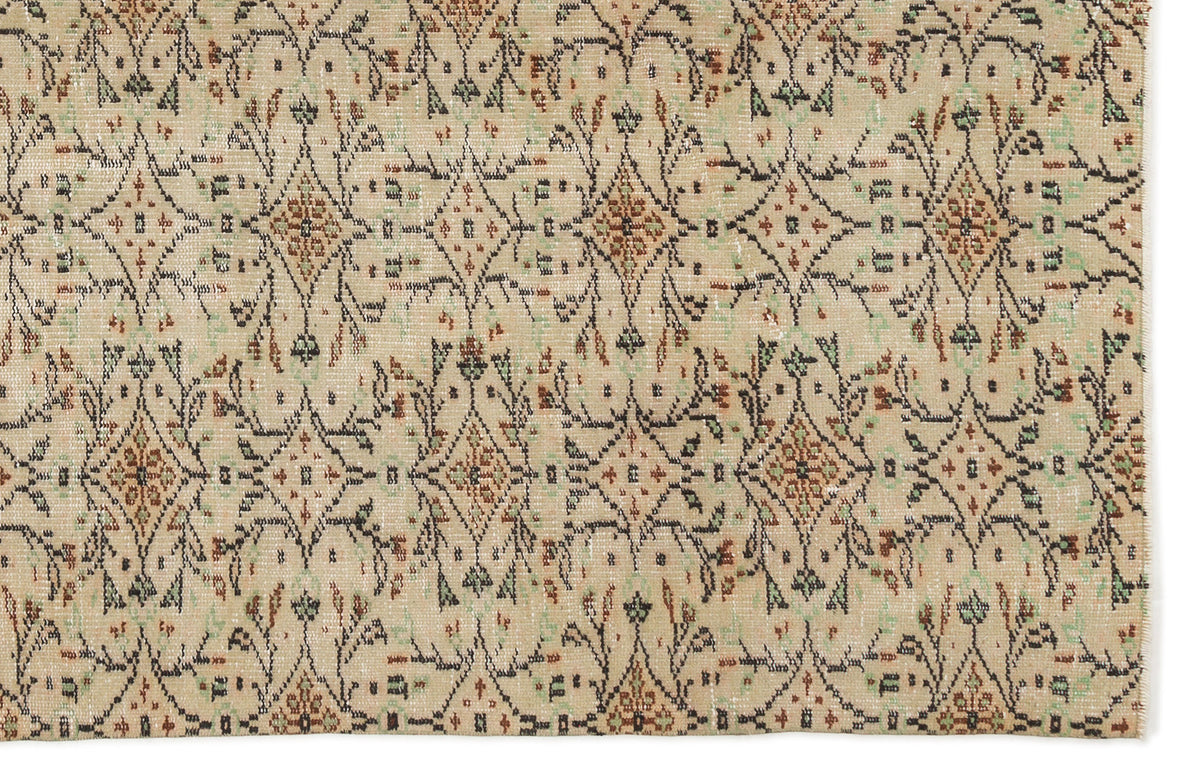 Beige rug with a repeating diamond lattice pattern in black, rust, and sage green.