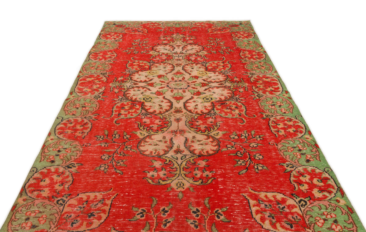Red and green vintage-style rug with a central floral medallion and a decorative border on a white background.