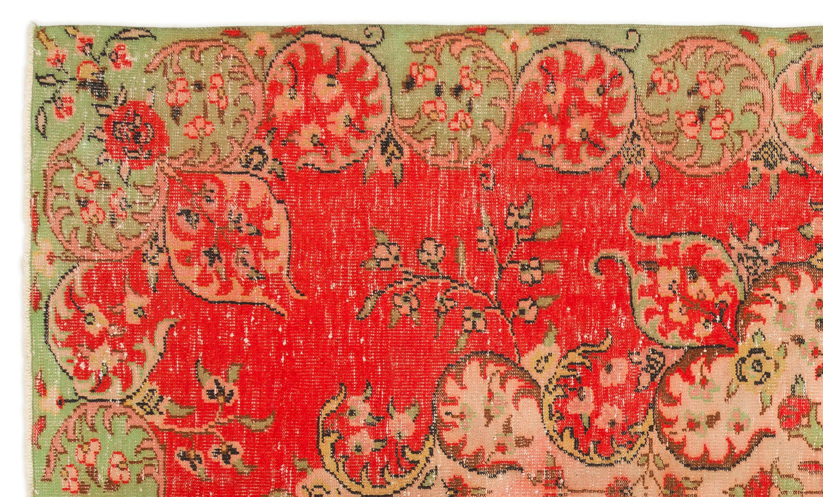 Red and sage green vintage-style rug with a distressed floral medallion pattern.
