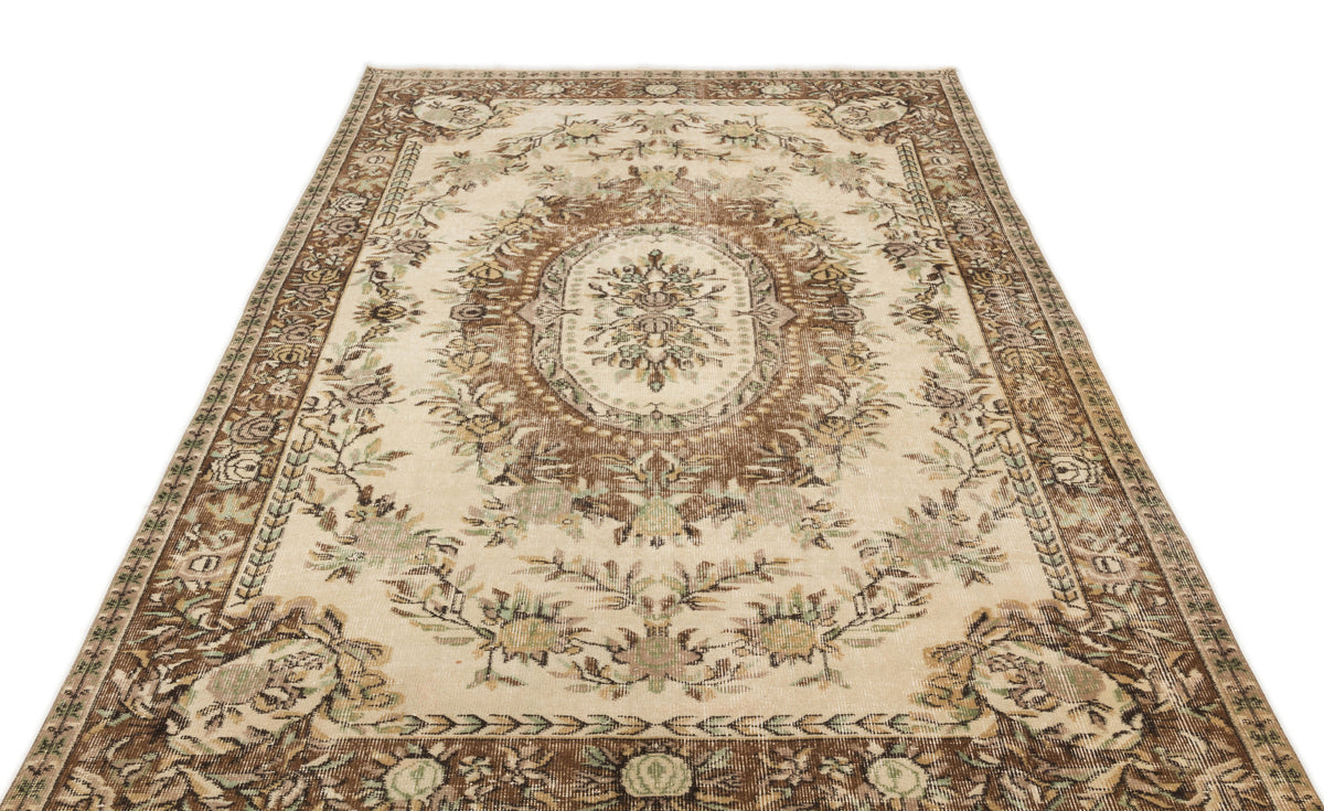 Beige and brown traditional rug with a central floral medallion and ornate border on a white background.