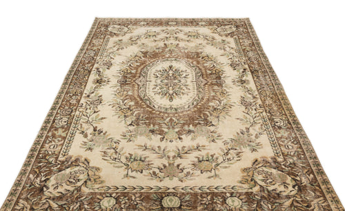 Load image 1 in gallery view. Beige and brown traditional rug with a central floral medallion and ornate border on a white background.