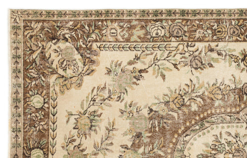 Load image 1 in gallery view. Beige and brown traditional rug with a distressed floral border and central botanical pattern.