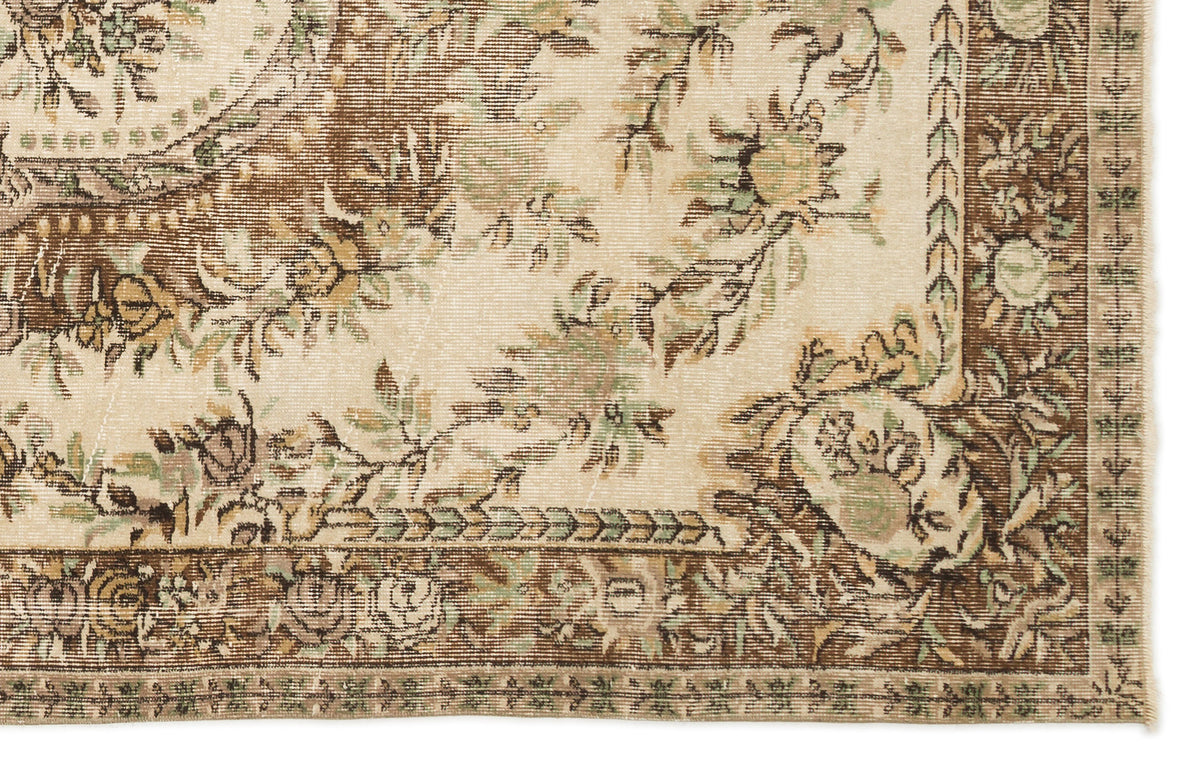Distressed beige rug with brown and sage green floral medallion pattern and a detailed botanical border.