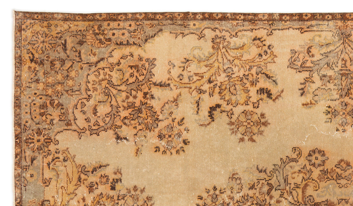 Distressed beige and brown vintage-style rug with a faded floral medallion pattern and a dark decorative border.