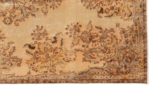 Load image 1 in gallery view. Distressed tan rug with a dark brown floral medallion pattern and a detailed border.