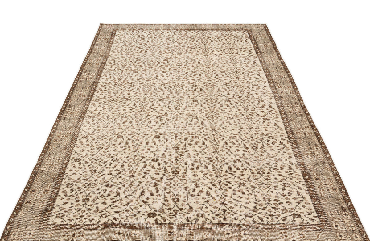 Beige and brown vintage-style rug with an intricate floral medallion pattern and a distressed border.