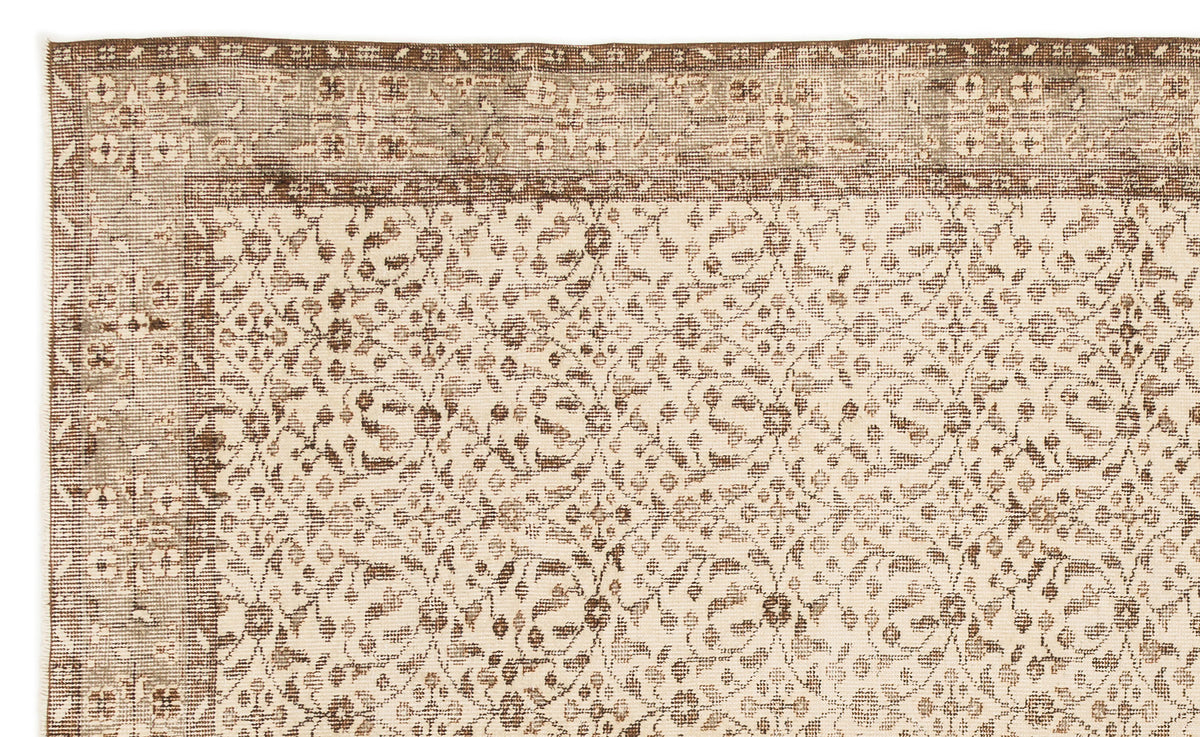 Beige and brown rug with a distressed floral medallion pattern and a wide decorative border.