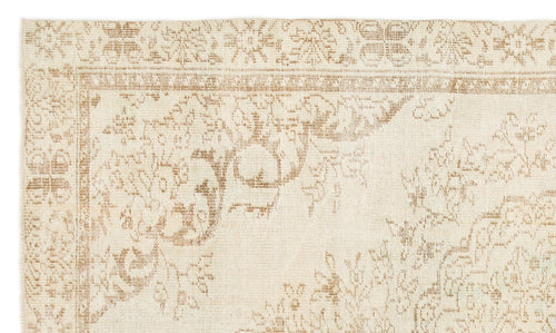 Load image 1 in gallery view. Beige and tan rug with a faded, traditional floral medallion pattern and a decorative border.