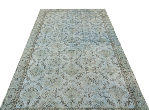 Load image 1 in gallery view. Light blue and grey distressed rug with a traditional floral medallion pattern and a decorative border.