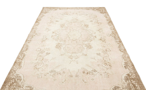 Load image 1 in gallery view. Beige and cream vintage-style rug with a faded central floral medallion and ornate border on a white background.