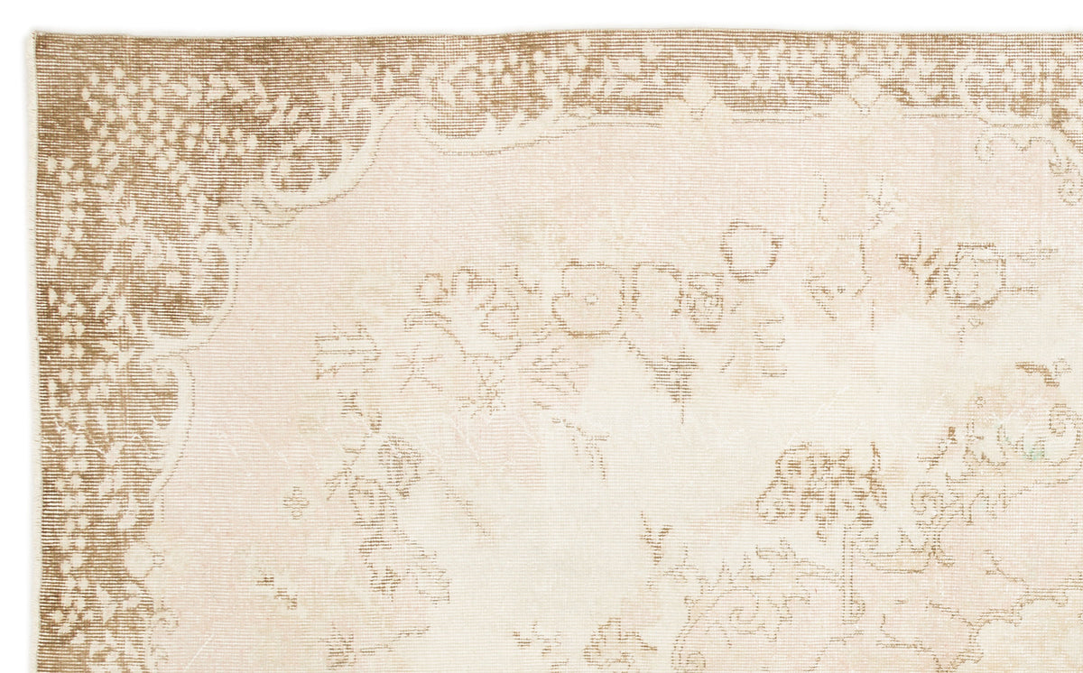 Beige and cream rug with a faded, traditional floral medallion pattern and a decorative border.