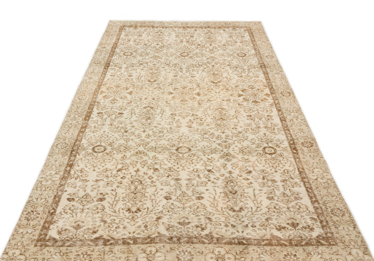 Beige and brown vintage-style rug with a distressed traditional floral medallion pattern on a white background.