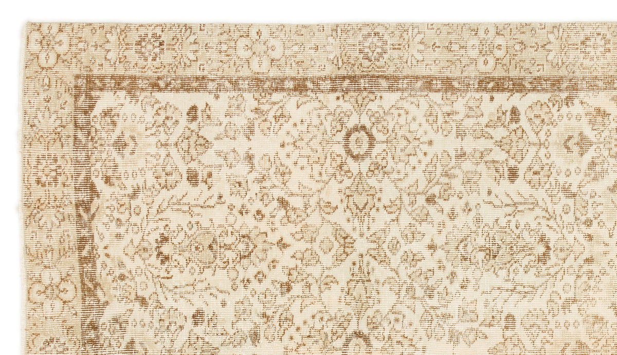 Beige and tan traditional rug with a distressed floral medallion pattern and a decorative border.