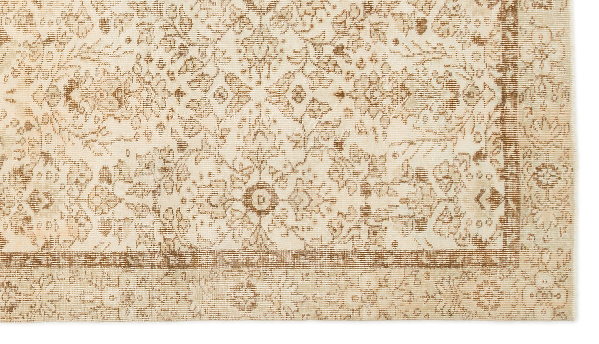 Beige and tan rug with a distressed traditional floral medallion pattern and a bordered edge.