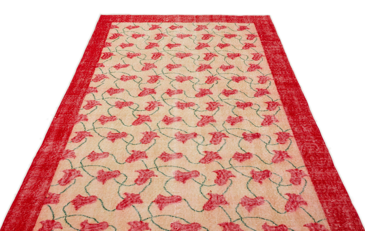 Beige rug with a red floral vine pattern and a solid red border on a white background.