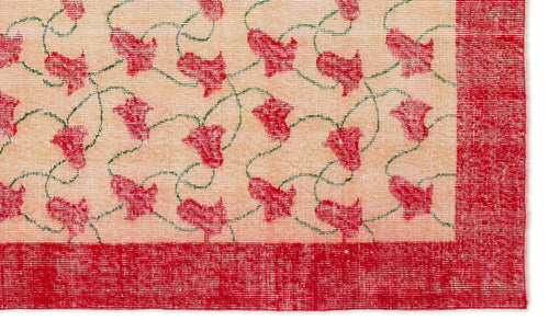 Load image 1 in gallery view. Peach rug with a repeating pattern of red floral motifs connected by thin green vines and a solid red border.