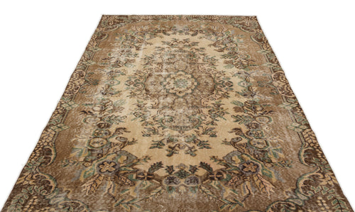 Load image 1 in gallery view. Distressed brown and beige vintage-style rug with a central floral medallion and ornate border.