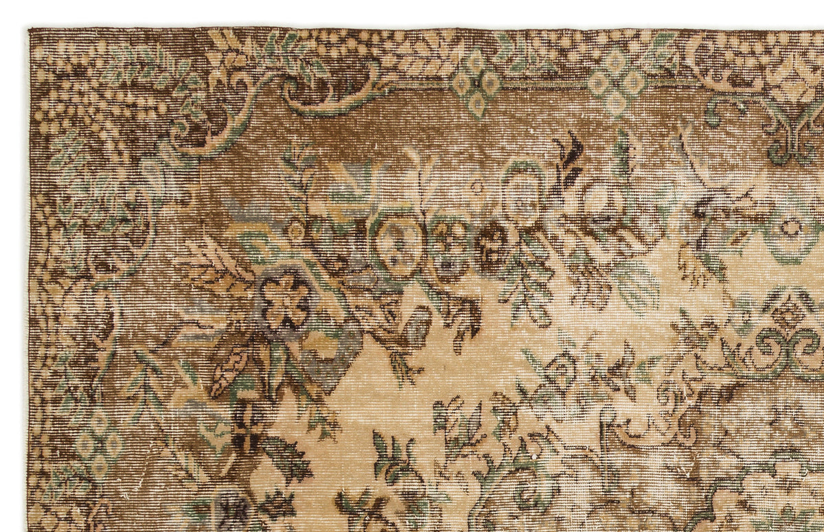 Distressed brown and beige traditional rug with faded floral and vine motifs.