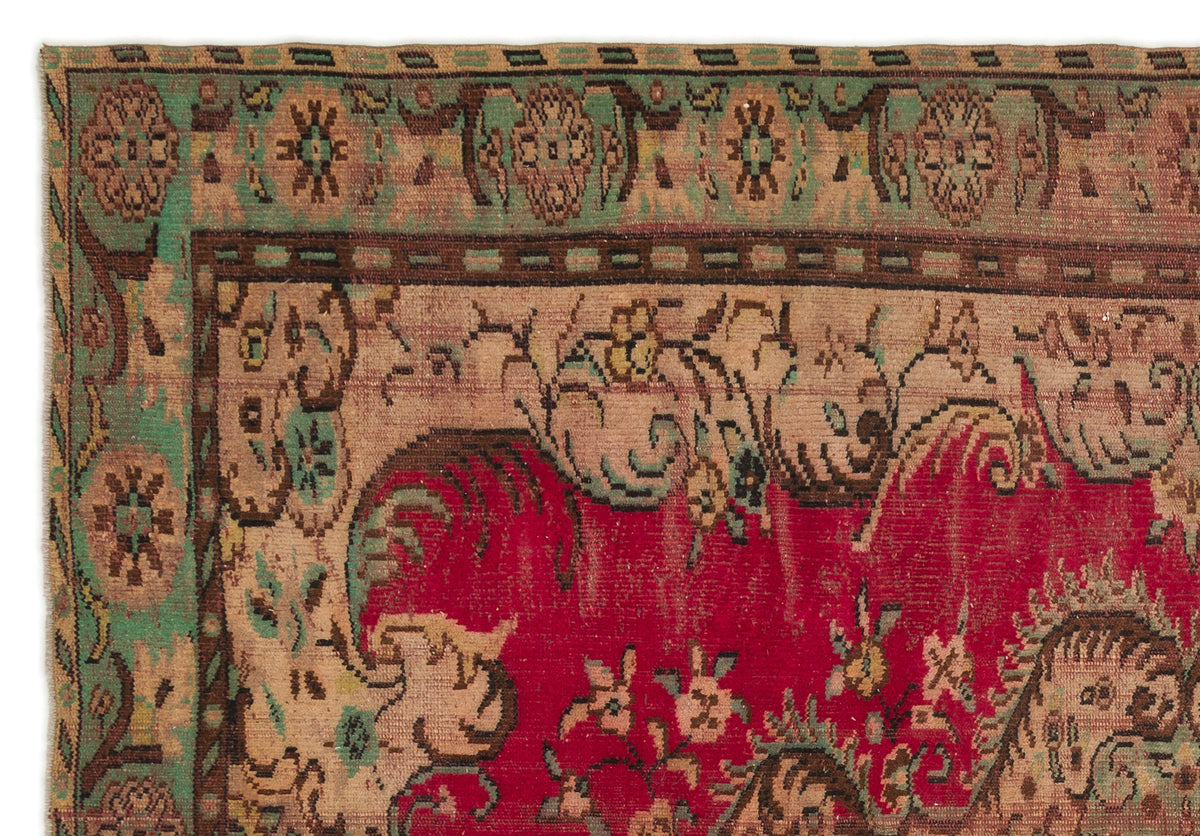 Vintage-style rug with a red central field, beige floral motifs, and a green decorative border.