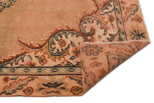 Load image 1 in gallery view. Terracotta and sage green vintage-style rug with a floral medallion pattern and a folded corner on a white background.