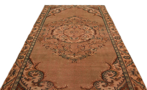 Load image 1 in gallery view. Distressed terracotta rug with a central floral medallion and ornate border in muted green and brown tones.