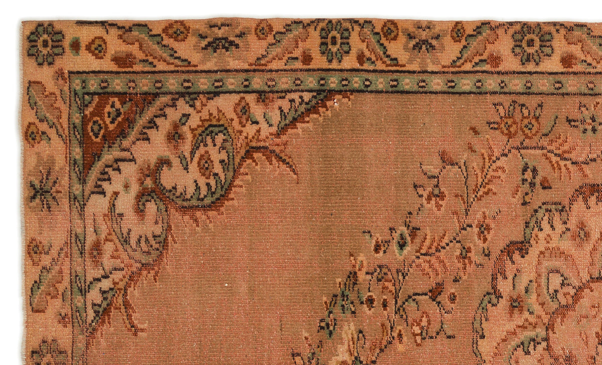 Terracotta rug with a traditional floral medallion border in sage green, brown, and cream.
