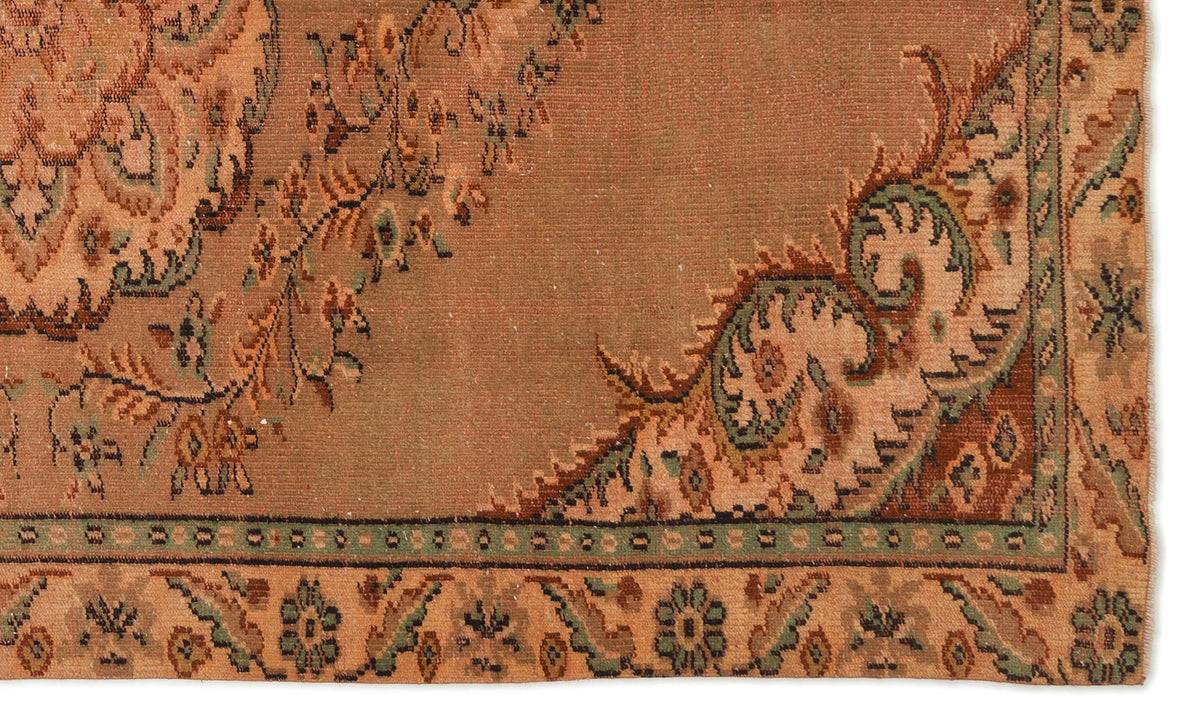 Terracotta rug with a traditional floral medallion pattern in sage green and dark brown, featuring a detailed border.