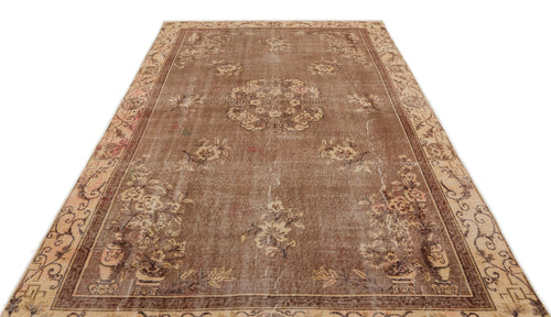 Load image 1 in gallery view. Brown vintage-style rug with a central floral medallion, distressed texture, and a decorative border.