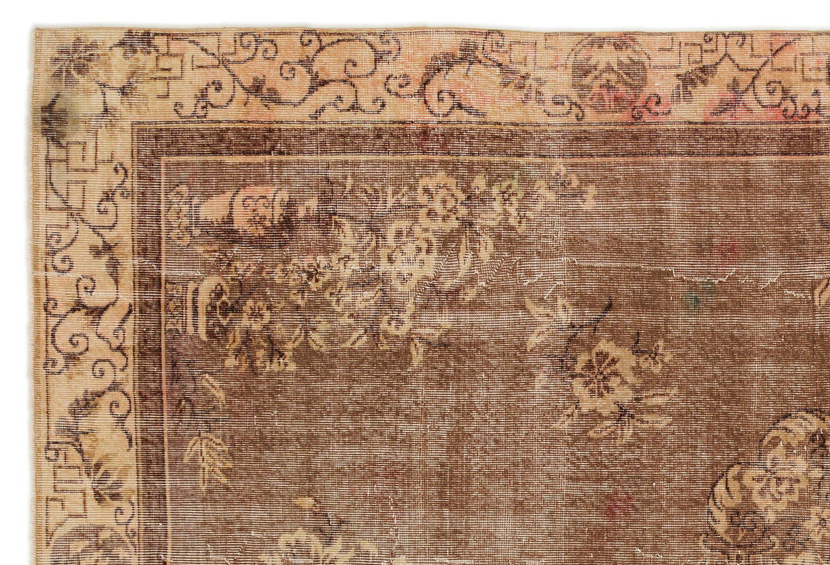 Brown and beige vintage-style rug with a floral medallion pattern and a decorative scrolled border.