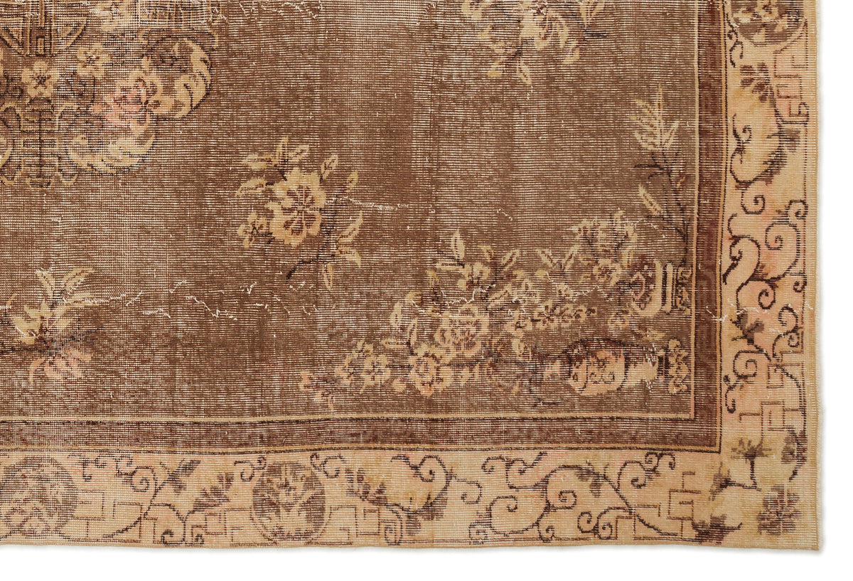 Brown vintage-style rug with a distressed floral medallion pattern and a beige border featuring scrollwork motifs.