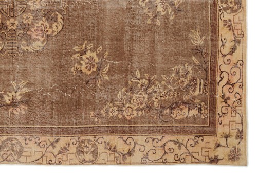 Load image 1 in gallery view. Brown vintage-style rug with a distressed floral medallion pattern and a beige border featuring scrollwork motifs.