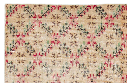 Load image 1 in gallery view. Tan rug with a repeating diamond lattice pattern featuring red, green, and black floral vine motifs.