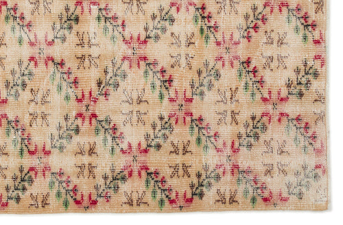 Load image 1 in gallery view. Beige rug with a repeating diamond lattice pattern featuring red and green floral accents on a white background.