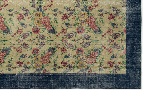 Load image 1 in gallery view. Beige rug with a distressed floral pattern in red, yellow, and blue, featuring a wide dark blue border.