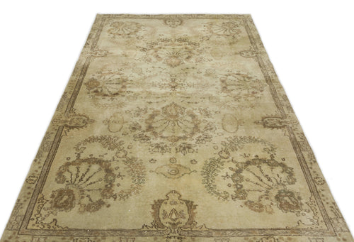 Load image 1 in gallery view. Beige and brown distressed vintage-style rug with a faded floral medallion pattern and a decorative border.