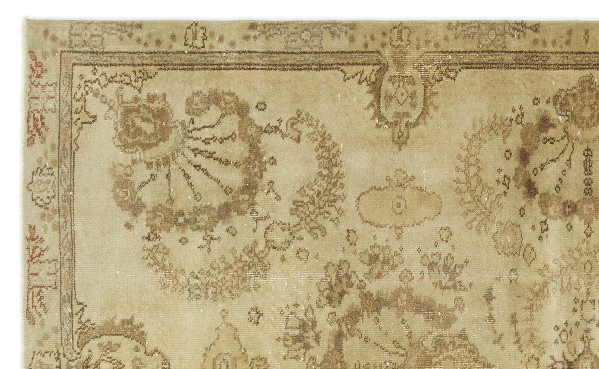 Beige and brown vintage-style rug with a distressed floral medallion pattern and a decorative border.