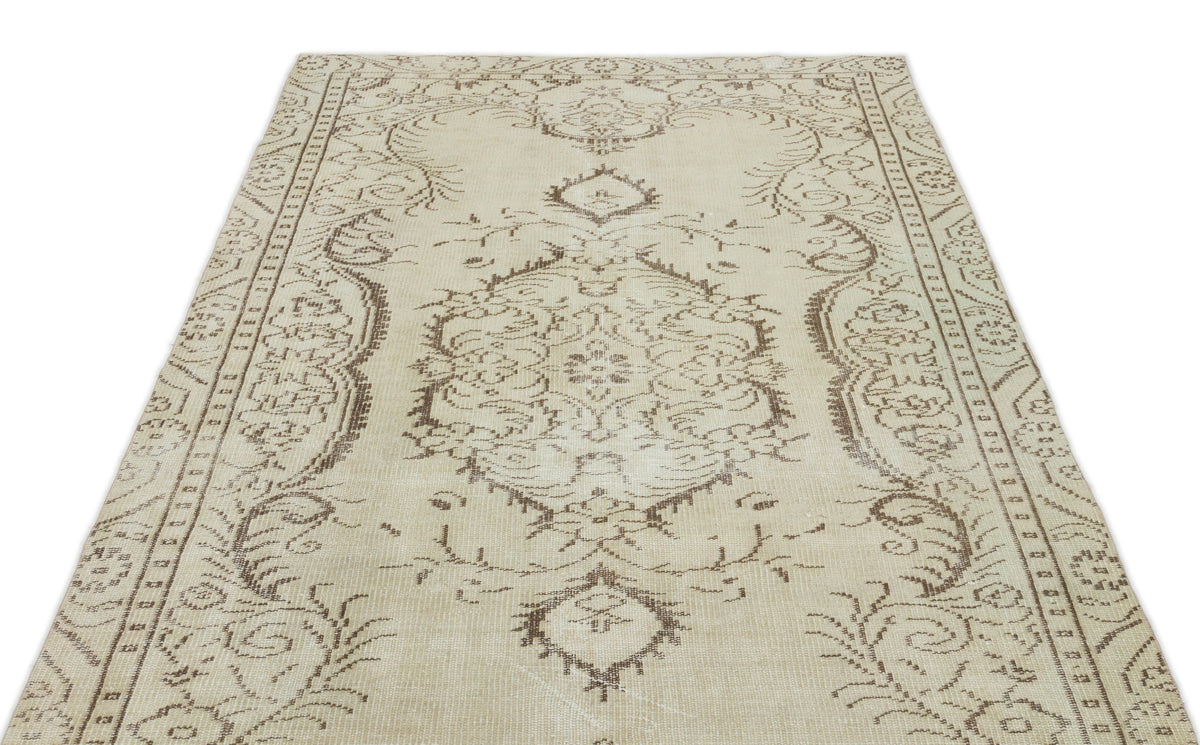 Beige and brown vintage-style rug with a central medallion and ornate floral border on a white background.