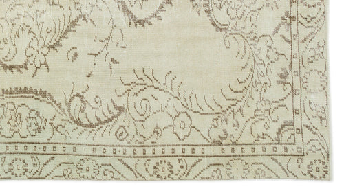 Load image 1 in gallery view. Beige rug with a brown outline of floral and vine motifs and a geometric border.