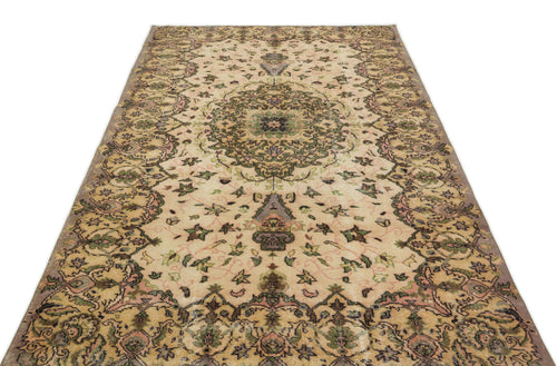 Load image 1 in gallery view. Beige vintage-style rug with a central floral medallion and intricate botanical motifs in green, pink, and charcoal.