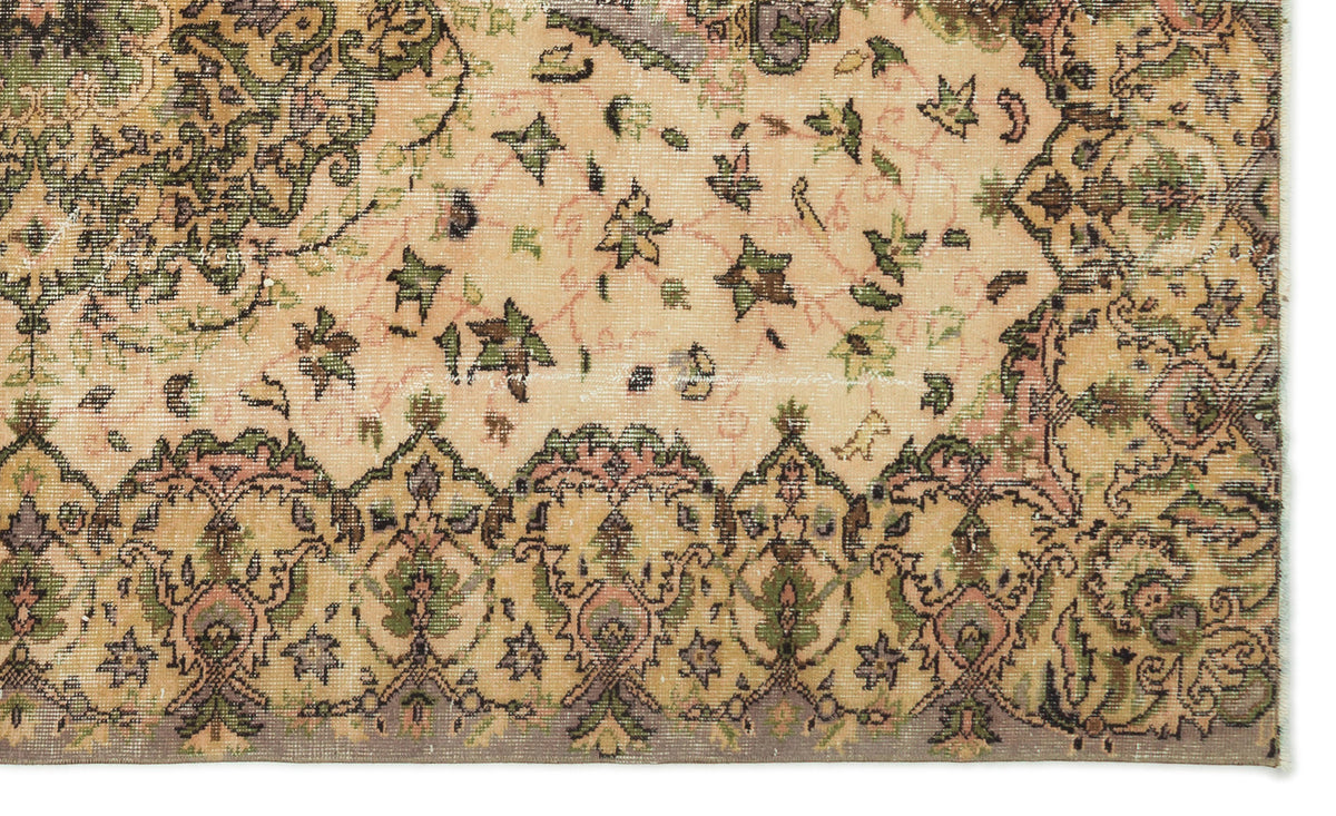 Distressed beige rug with a traditional floral medallion pattern in olive green, charcoal, and muted pink.