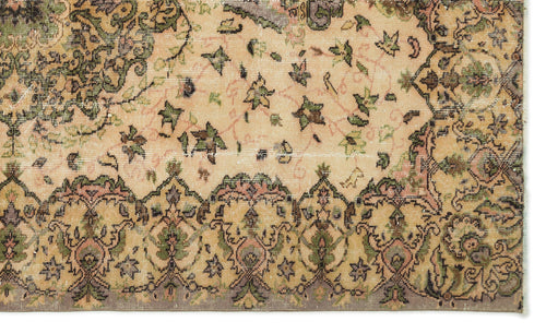 Load image 1 in gallery view. Distressed beige rug with a traditional floral medallion pattern in olive green, charcoal, and muted pink.