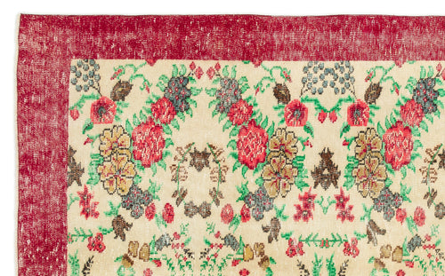 Load image 1 in gallery view. Cream rug with a distressed red border and a multi-colored floral pattern in red, green, and brown.