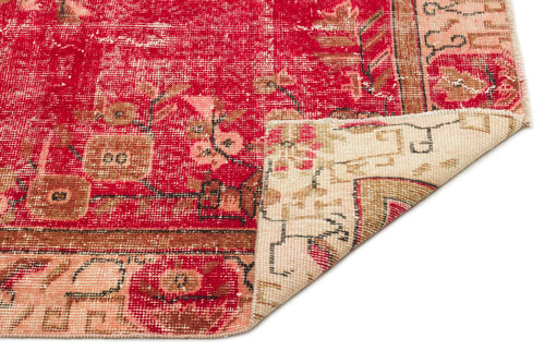 Load image 1 in gallery view. Distressed red and beige vintage-style rug with a floral medallion pattern, showing a folded corner on a white background.