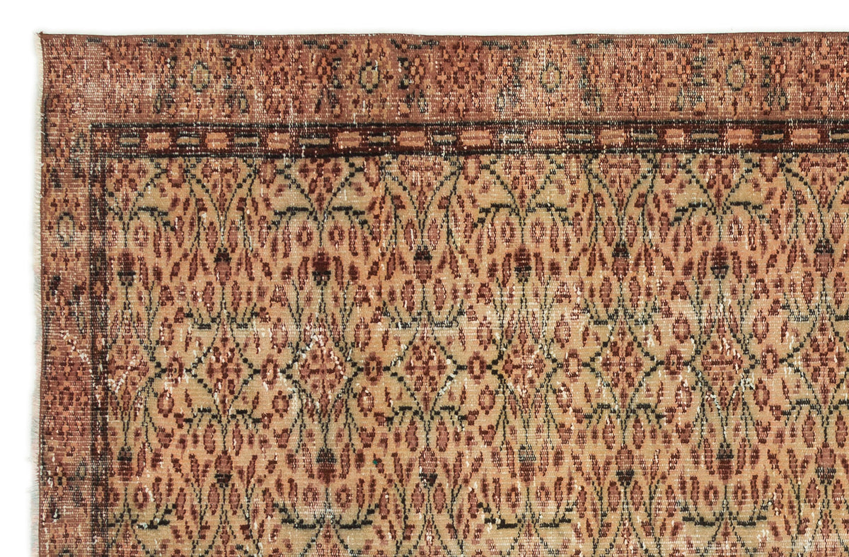 Rust and beige vintage-style rug with a repeating floral trellis pattern and a decorative border.