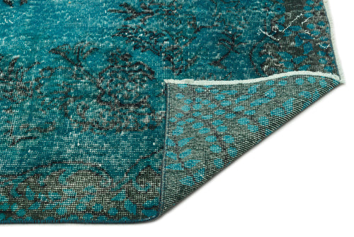 Load image 1 in gallery view. Teal and black distressed floral rug with a folded corner revealing the woven backing.