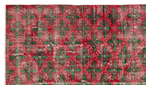 Load image 1 in gallery view. Red and green distressed rug with a repeating floral medallion pattern on a white background.